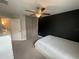 Comfortable bedroom with a black accent wall and ceiling fan at 1596 Ludington Ave, Wesley Chapel, FL 33543