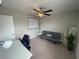 Bedroom features ceiling fan, neutral walls, grey futon, desk, and simple shelving for versatile use at 1596 Ludington Ave, Wesley Chapel, FL 33543