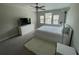 Bright bedroom featuring a large bed, TV, ceiling fan, and windows at 1596 Ludington Ave, Wesley Chapel, FL 33543