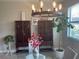 Dining area with stylish chandelier, glass table, and decorative cabinets at 1596 Ludington Ave, Wesley Chapel, FL 33543