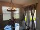 Dining area with a modern chandelier, glass table, and view of the outdoors at 1596 Ludington Ave, Wesley Chapel, FL 33543
