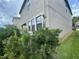 Exterior view featuring lush greenery surrounding the home's AC unit at 1596 Ludington Ave, Wesley Chapel, FL 33543
