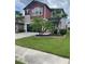 Charming two-story home with a well-manicured lawn and palm trees adding to its curb appeal at 1596 Ludington Ave, Wesley Chapel, FL 33543