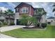 Charming two-story home with a well-manicured lawn and palm trees adding to its curb appeal at 1596 Ludington Ave, Wesley Chapel, FL 33543