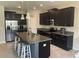 Modern kitchen with dark cabinets, stainless steel appliances, granite countertops, and an island at 1596 Ludington Ave, Wesley Chapel, FL 33543