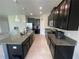 Spacious kitchen with dark cabinets, granite counters, stainless appliances, and large island at 1596 Ludington Ave, Wesley Chapel, FL 33543