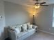Neutral living room with couch, lamp, ceiling fan, and carpeted floors at 1596 Ludington Ave, Wesley Chapel, FL 33543