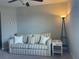 Comfortable living room featuring a striped couch, end table, and floor lamp at 1596 Ludington Ave, Wesley Chapel, FL 33543