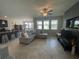 Open-concept living room with tile flooring, seamlessly connected to the kitchen and dining area at 1596 Ludington Ave, Wesley Chapel, FL 33543