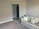 Bright living room featuring neutral walls and a comfortable, striped couch at 1596 Ludington Ave, Wesley Chapel, FL 33543