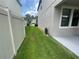 Side yard with grass between two houses, partially fenced at 1596 Ludington Ave, Wesley Chapel, FL 33543