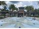 Community splash pad with palm trees and covered seating area at 1596 Ludington Ave, Wesley Chapel, FL 33543