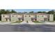 A row of townhouses, showcasing individual garages, neutral color palette, and manicured lawns at 17261 English Chestnut Way, Land O Lakes, FL 34638