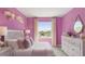 The bedroom is painted in a soft purple, offering a view and accented by decor, offering serenity and charm at 17469 Spanish Oak Loop, Land O Lakes, FL 34638