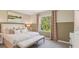 A bedroom with a large window, neutral decor, and a comfortable bed with decorative pillows at 17469 Spanish Oak Loop, Land O Lakes, FL 34638