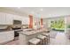 An open-concept kitchen with white cabinets, stainless steel appliances, and seating at the island at 17469 Spanish Oak Loop, Land O Lakes, FL 34638