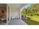 Cozy patio featuring white Adirondack chairs, a glimpse of the lush green outdoors, and a peaceful seating area at 17469 Spanish Oak Loop, Land O Lakes, FL 34638