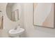 A powder room with a pedestal sink, round mirror, and neutral decor for a clean, modern look at 17469 Spanish Oak Loop, Land O Lakes, FL 34638