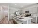 Modern kitchen featuring an island with seating, stainless steel appliances, and shaker style cabinets at 17491 Spanish Oak Loop, Land O Lakes, FL 34638