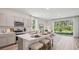 Bright, modern kitchen with stainless steel appliances, island, and dining area with sliding doors to the outdoors at 17491 Spanish Oak Loop, Land O Lakes, FL 34638
