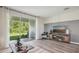 Spacious living room featuring wood floors, a large slider to the back yard, and stylish decor at 17491 Spanish Oak Loop, Land O Lakes, FL 34638