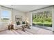 Bright living room with stylish decor, hardwood flooring, and a sliding door to the patio at 17491 Spanish Oak Loop, Land O Lakes, FL 34638