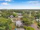 Expansive aerial view of a verdant neighborhood with lush trees and a distant cityscape at 209 Se Jefferson N Cir, St Petersburg, FL 33702