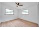 This bedroom features two windows, a ceiling fan, and light wood-look floors at 209 Se Jefferson N Cir, St Petersburg, FL 33702