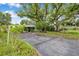 Long driveway leading to a charming home beneath a large, mature tree at 209 Se Jefferson N Cir, St Petersburg, FL 33702