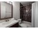 Bathroom with a white sink and wooden vanity, a dark tile shower with contrasting trim and white curtain at 225 Pompano Se Dr # D, St Petersburg, FL 33705