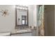 Bathroom with a granite vanity and decorative mirror, complemented by a shower with beach themed curtain at 225 Pompano Se Dr # D, St Petersburg, FL 33705