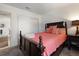 Bedroom showcasing a dark wood bed frame, salmon colored bedding and a view to adjoining space at 225 Pompano Se Dr # D, St Petersburg, FL 33705