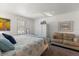 Bright bedroom featuring a decorative bedspread, white dresser and cozy seating area at 225 Pompano Se Dr # D, St Petersburg, FL 33705