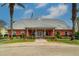 Exterior view of a clubhouse featuring manicured lawns and palm trees at 225 Pompano Se Dr # D, St Petersburg, FL 33705
