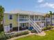 Beautiful two-story yellow townhouse featuring a private patio and white railings at 225 Pompano Se Dr # D, St Petersburg, FL 33705