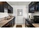 Well-lit kitchen with granite countertops, stainless steel appliances, and sleek black cabinetry at 225 Pompano Se Dr # D, St Petersburg, FL 33705