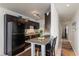 Compact kitchen with granite countertops, black appliances, an eat-in area, and a view into the hallway at 225 Pompano Se Dr # D, St Petersburg, FL 33705