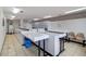 Well-lit community laundry room with multiple washers, dryers, folding tables, and seating at 225 Pompano Se Dr # D, St Petersburg, FL 33705