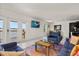 Bright living room featuring a colorful rug, modern furniture, and doors leading to a balcony with a water view at 225 Pompano Se Dr # D, St Petersburg, FL 33705