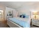 Serene main bedroom with a white bed frame, blue accents, and access to an en-suite bathroom at 225 Pompano Se Dr # D, St Petersburg, FL 33705