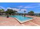Community pool surrounded by lounge chairs, tables, palm trees and lush landscaping at 225 Pompano Se Dr # D, St Petersburg, FL 33705