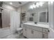 Bathroom with a single sink vanity, large mirror and shower-tub combo with white shower curtain at 2469 Stapleford Pl, Wesley Chapel, FL 33543