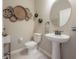 Tastefully decorated half-bathroom with pedestal sink and modern wall decor at 2469 Stapleford Pl, Wesley Chapel, FL 33543