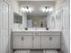 Bathroom with dual vanity, framed mirror, and tiled flooring at 2469 Stapleford Pl, Wesley Chapel, FL 33543