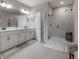 Bathroom with dual vanity, framed mirror, and tiled shower at 2469 Stapleford Pl, Wesley Chapel, FL 33543