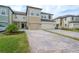 Stylish townhouse exterior showcasing a brick driveway and well-maintained lawn at 2469 Stapleford Pl, Wesley Chapel, FL 33543
