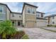 Inviting townhouse with a two-car garage, brick paved driveway, and manicured landscaping at 2469 Stapleford Pl, Wesley Chapel, FL 33543