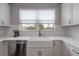 Farmhouse sink under window in a kitchen with white cabinets, stainless appliances and granite countertops at 2469 Stapleford Pl, Wesley Chapel, FL 33543