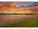 Stunning lake view with a vibrant sunset reflecting on the water at 2469 Stapleford Pl, Wesley Chapel, FL 33543