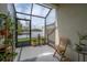Inviting screened patio area with a scenic water view and lush plants at 2469 Stapleford Pl, Wesley Chapel, FL 33543